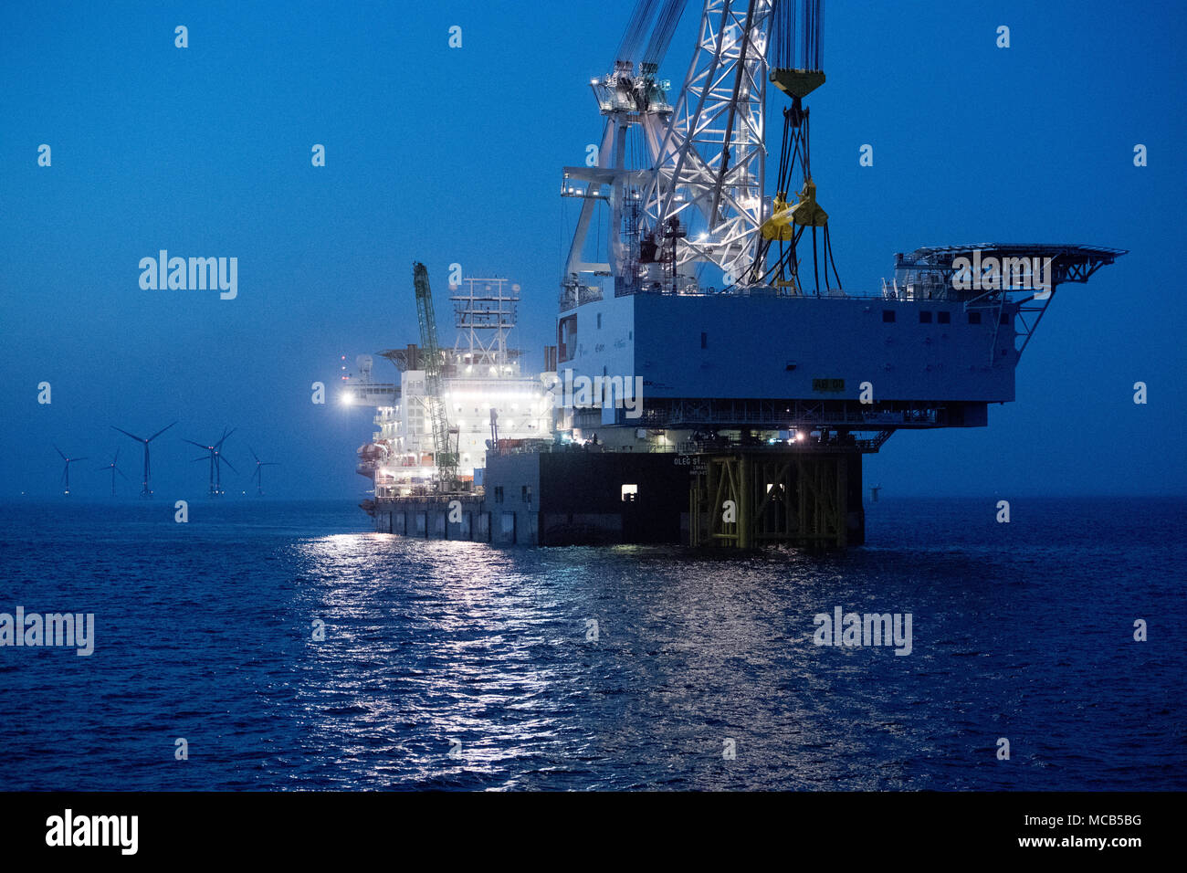 08 April 2018, Germany, Sassnitz: The 4,000 tons weighing transformer platform is being mounted with the help of crane ship 'Oleg Strashnov' at the offshore wind park 'Arkona' near Ruegen Island. Offshore wind park 'Arkona' is expected to be brought online in early 2019 delivering 385 megawatt of energy from 60 wind turbines. Energy company Eon and Norwegian energy company Statoil are investing around 1, 2 billion euro into the project. - NO WIRE SERVICE - Photo: Stefan Sauer/dpa-Zentralbild/dpa Stock Photo