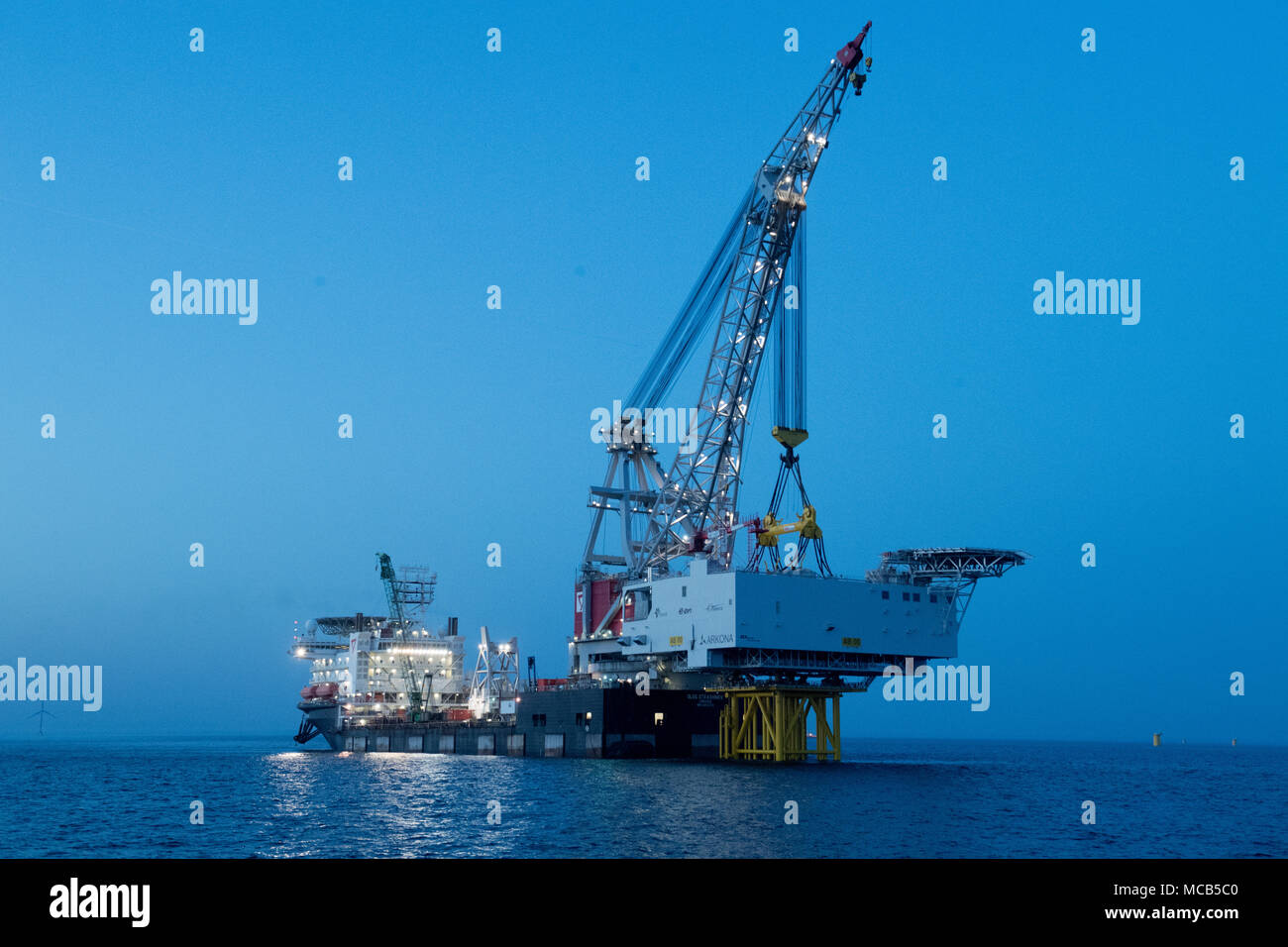 08 April 2018, Germany, Sassnitz: The 4,000 tons weighing transformer platform is being mounted with the help of crane ship 'Oleg Strashnov' at the offshore wind park 'Arkona' near Ruegen Island. Offshore wind park 'Arkona' is expected to be brought online in early 2019 delivering 385 megawatt of energy from 60 wind turbines. Energy company Eon and Norwegian energy company Statoil are investing around 1, 2 billion euro into the project. - NO WIRE SERVICE - Photo: Stefan Sauer/dpa-Zentralbild/dpa Stock Photo