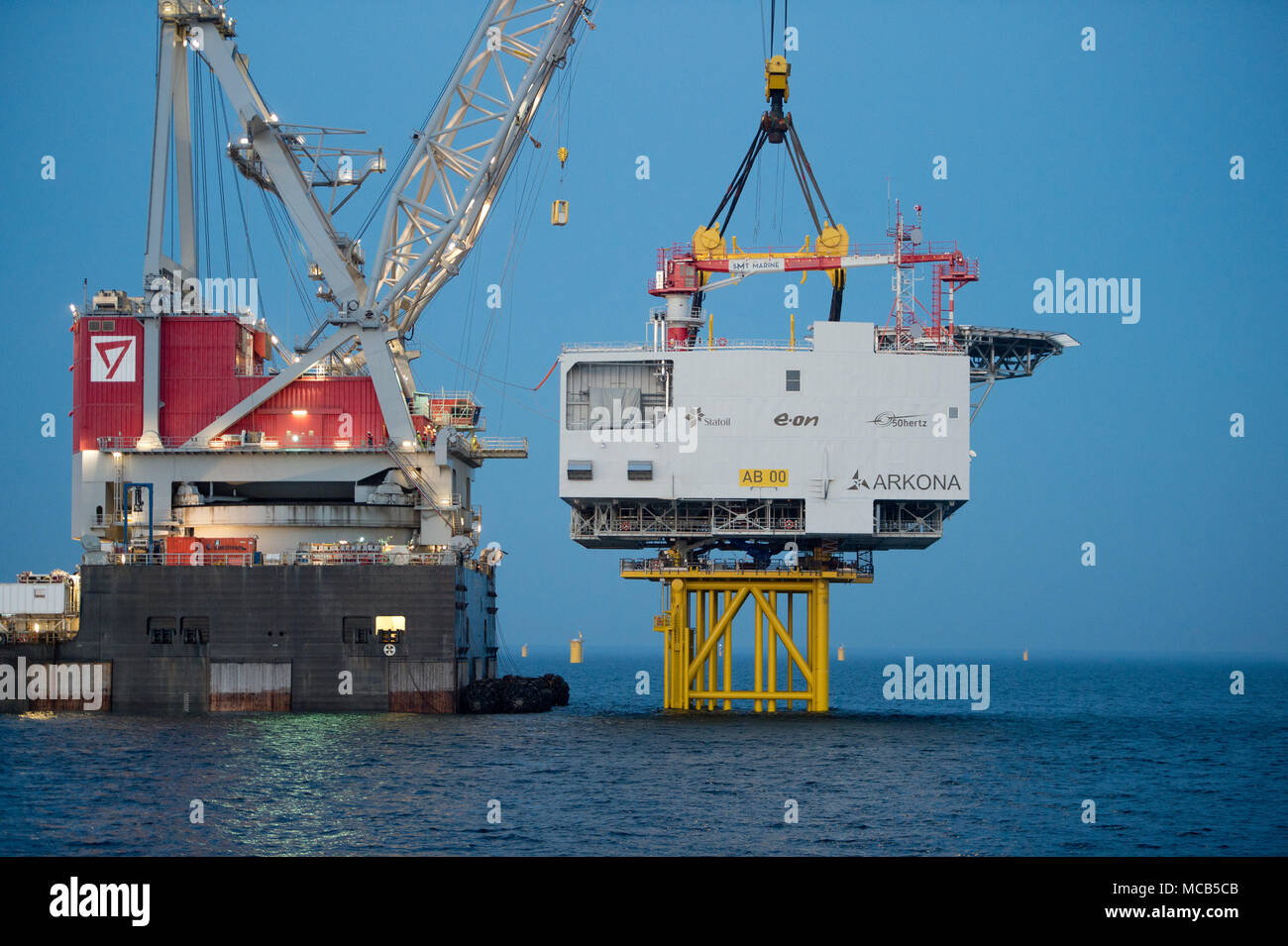 08 April 2018, Germany, Sassnitz: The 4,000 tons weighing transformer platform is being mounted with the help of crane ship 'Oleg Strashnov' at the offshore wind park 'Arkona' near Ruegen Island. Offshore wind park 'Arkona' is expected to be brought online in early 2019 delivering 385 megawatt of energy from 60 wind turbines. Energy company Eon and Norwegian energy company Statoil are investing around 1, 2 billion euro into the project. - NO WIRE SERVICE - Photo: Stefan Sauer/dpa-Zentralbild/dpa Stock Photo