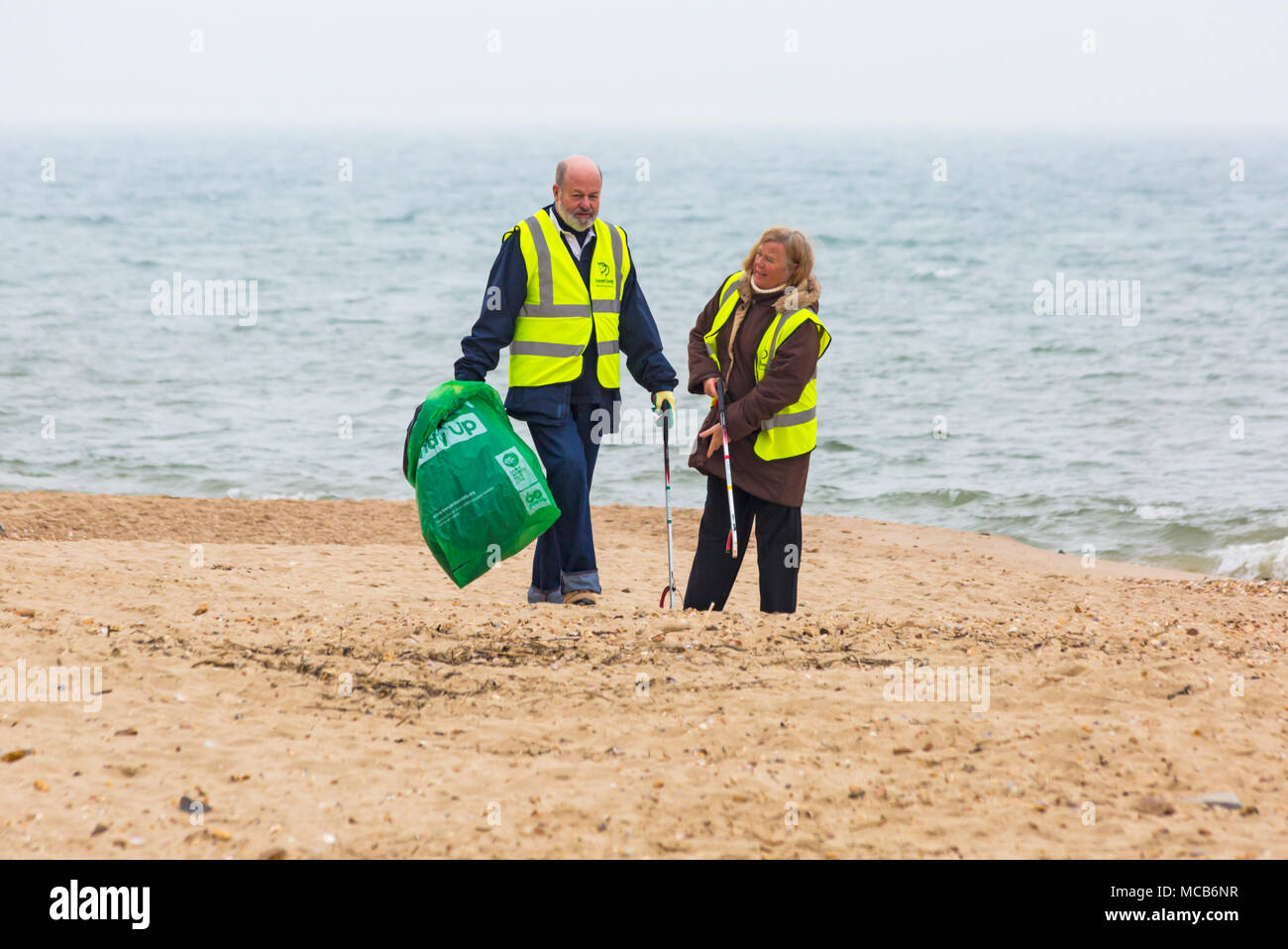 Bournemouth, Dorset, UK. 15th April 2018. Plastic Free Bournemouth hold their first community beach clean as part of Surfers against Sewage Spring Beach Clean. Volunteers take part in picking up litter between Boscombe Pier and Bournemouth Pier, despite the dreary weather with rain on its way. high visability clothing Credit: Carolyn Jenkins/Alamy Live News Stock Photo