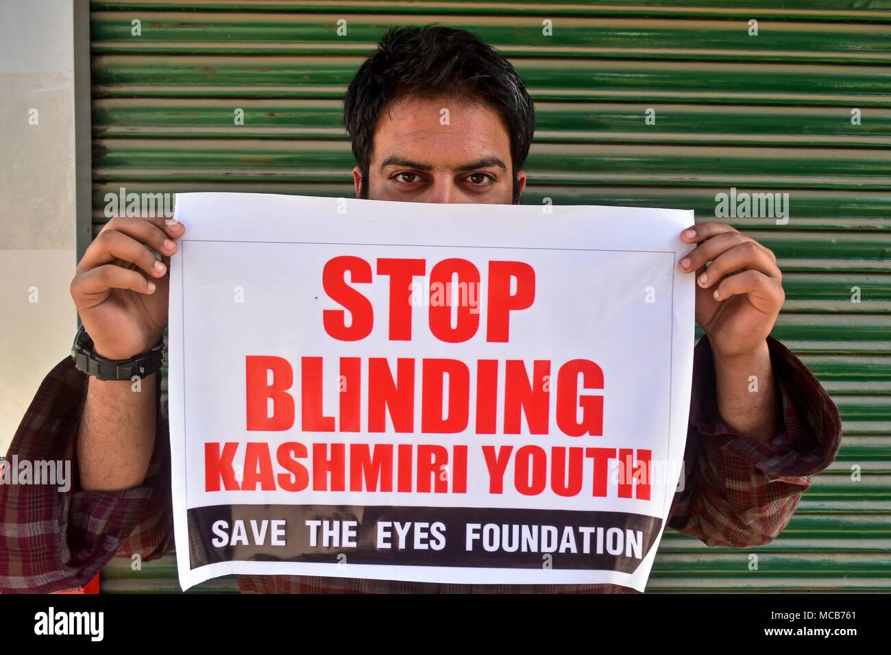 A demonstrator holds a placard during a protest against the use of pellet  guns on Kashmiris by the government forces in Srinagar, Indian administered  Kashmir. The members of a local NGO, staged