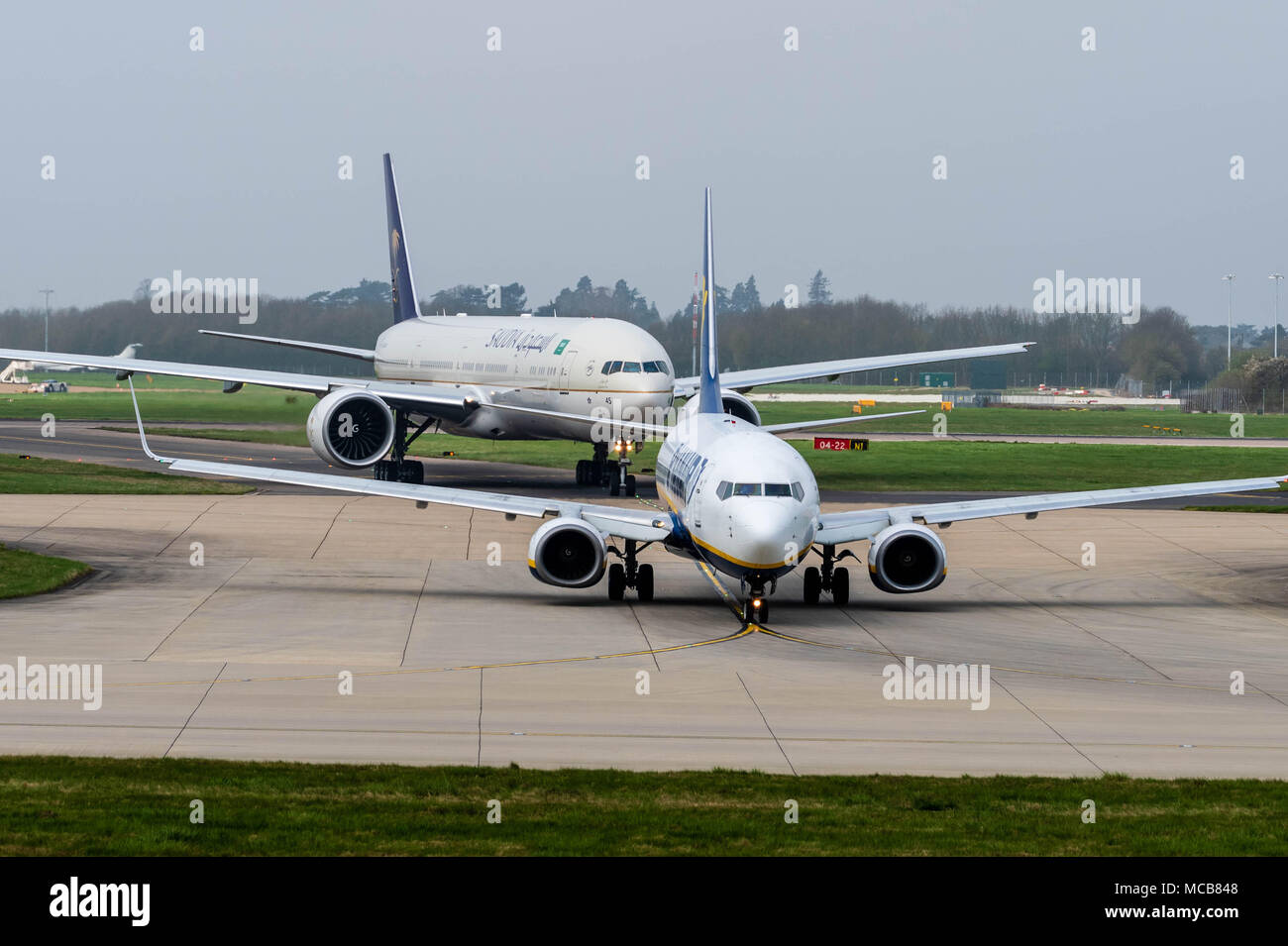 Stansted Airport, Essex, 15th April 2018  Aircraft movements at a foggy Stansted Airport in Essex, UK Ei-dcj Ryanair Boeing 737-8AS is followed by HZ-AK45 Saudi Arabian Airlines Boeing 777-300 on the taxi way Credit: Ian Davidson/Alamy Live News Stock Photo