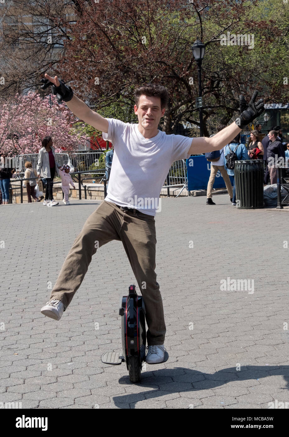 An Englishman living in New York riding an electric unicycle in Union Square Park in Manhattan, New York City. Stock Photo