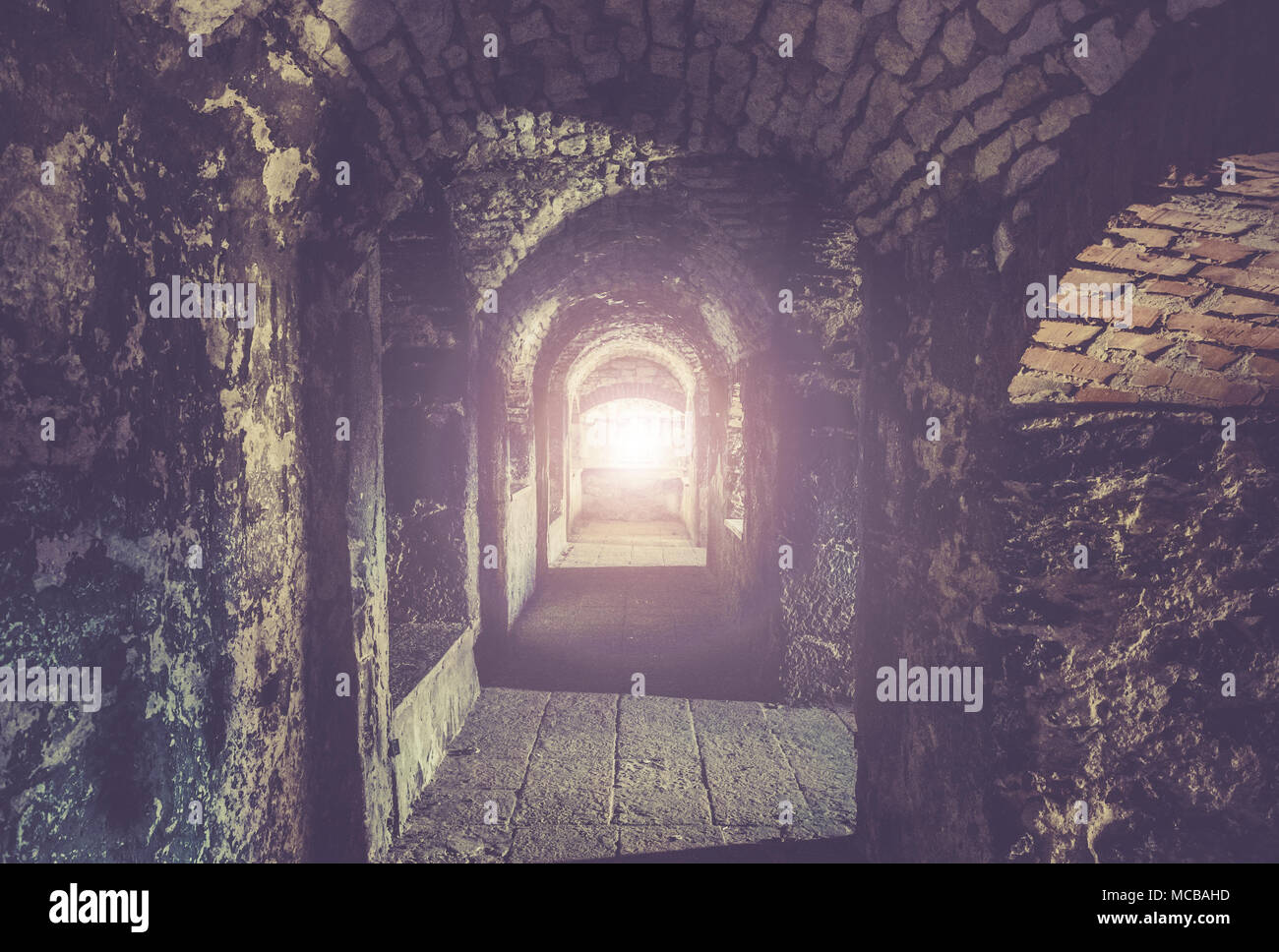 Medieval dungeon corridor with ray of light in the middle Stock Photo