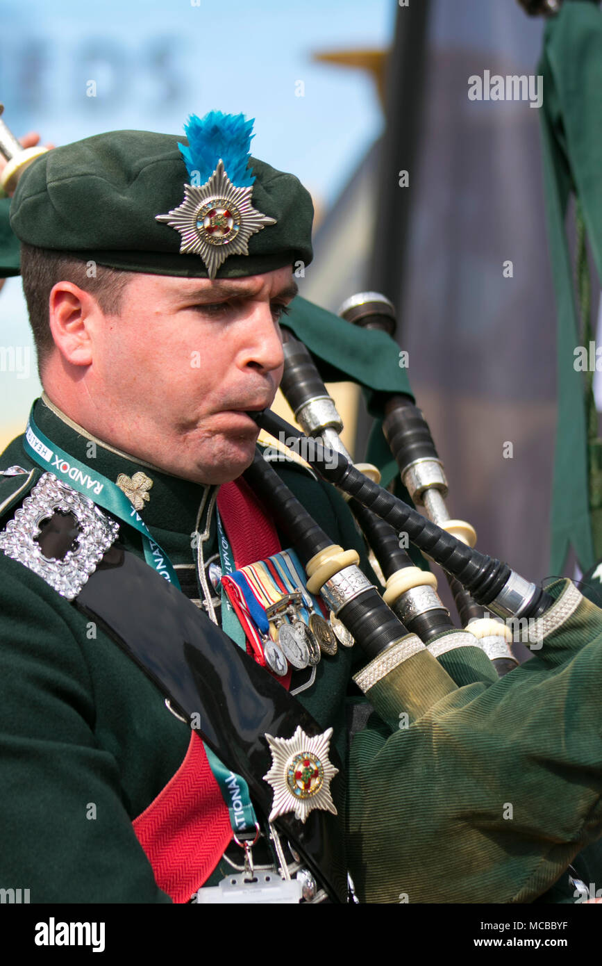 Uniformed musician of The Irish Guards or The Micks playing bagpipes