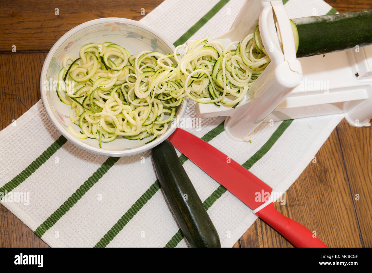 Spiral zucchini noodles called zoodles prepared in spiralizer kitchen gadget Stock Photo Alamy