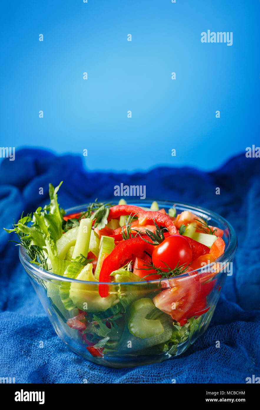 Bowl of salad with fresh vegetables on blue background Stock Photo Alamy