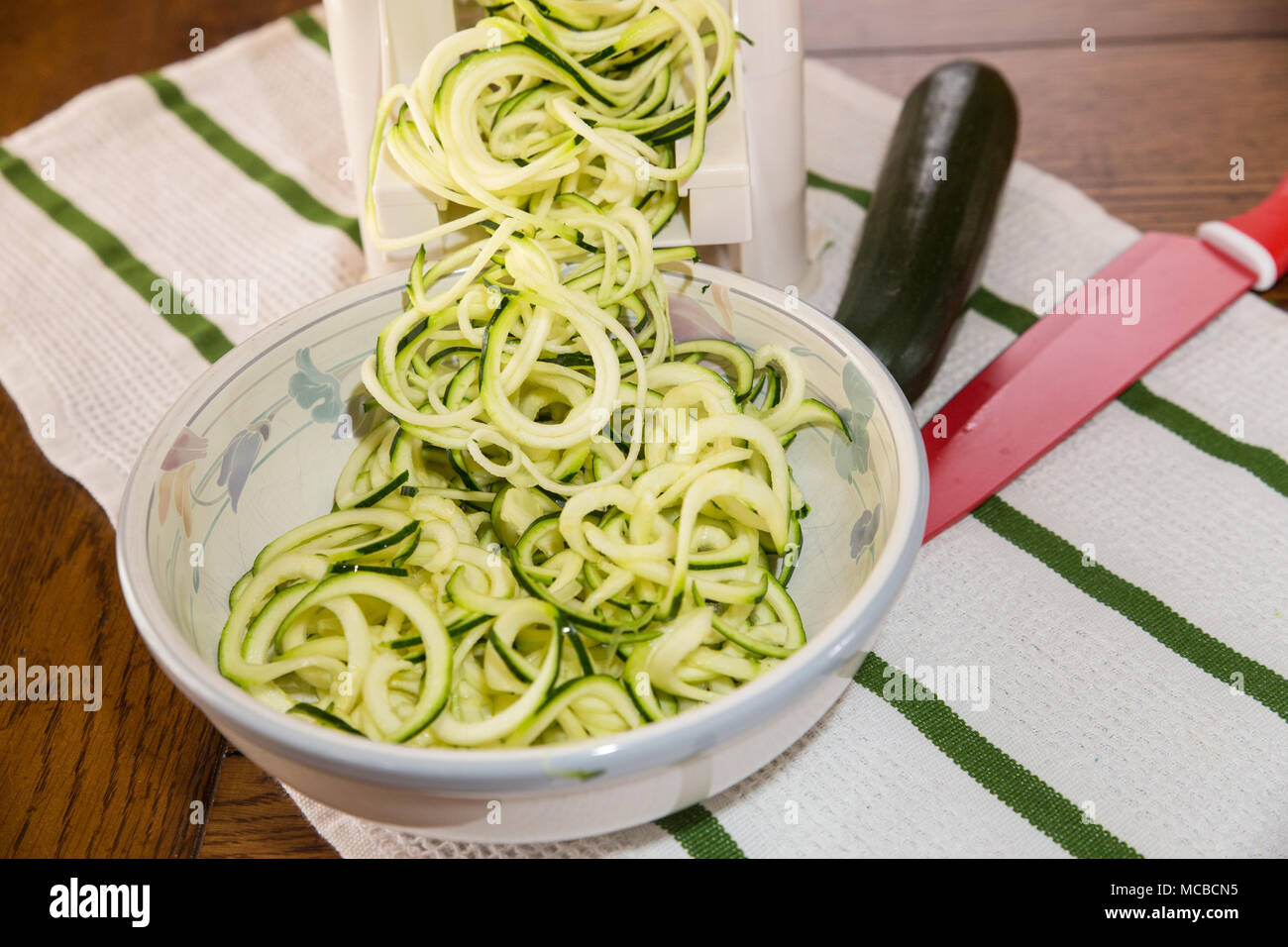 Spiral zucchini noodles called zoodles prepared in spiralizer kitchen gadget Stock Photo Alamy