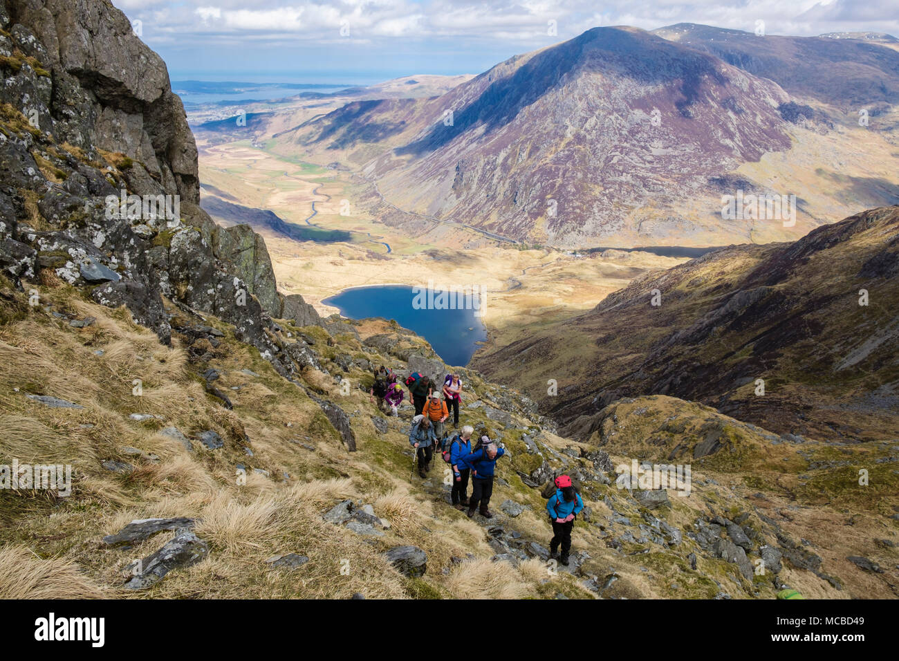 Hikers hiking up Seniors Ridge above Cwm Idwal with Pen yr Ole Wen behind in mountains of Snowdonia National Park. Ogwen, Conwy, Wales, UK, Britain Stock Photo
