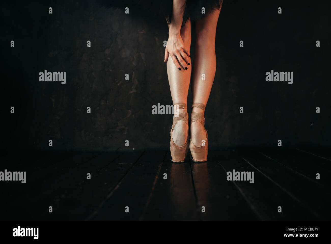 Ballet dancer legs in pointes, black wooden floor Stock Photo