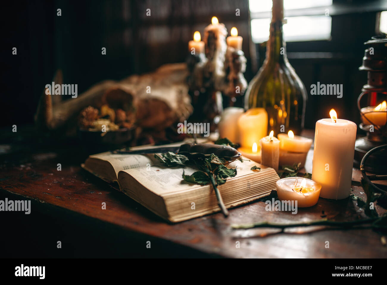 Witchcraft, dark magic, candles with ritual book Stock Photo - Alamy