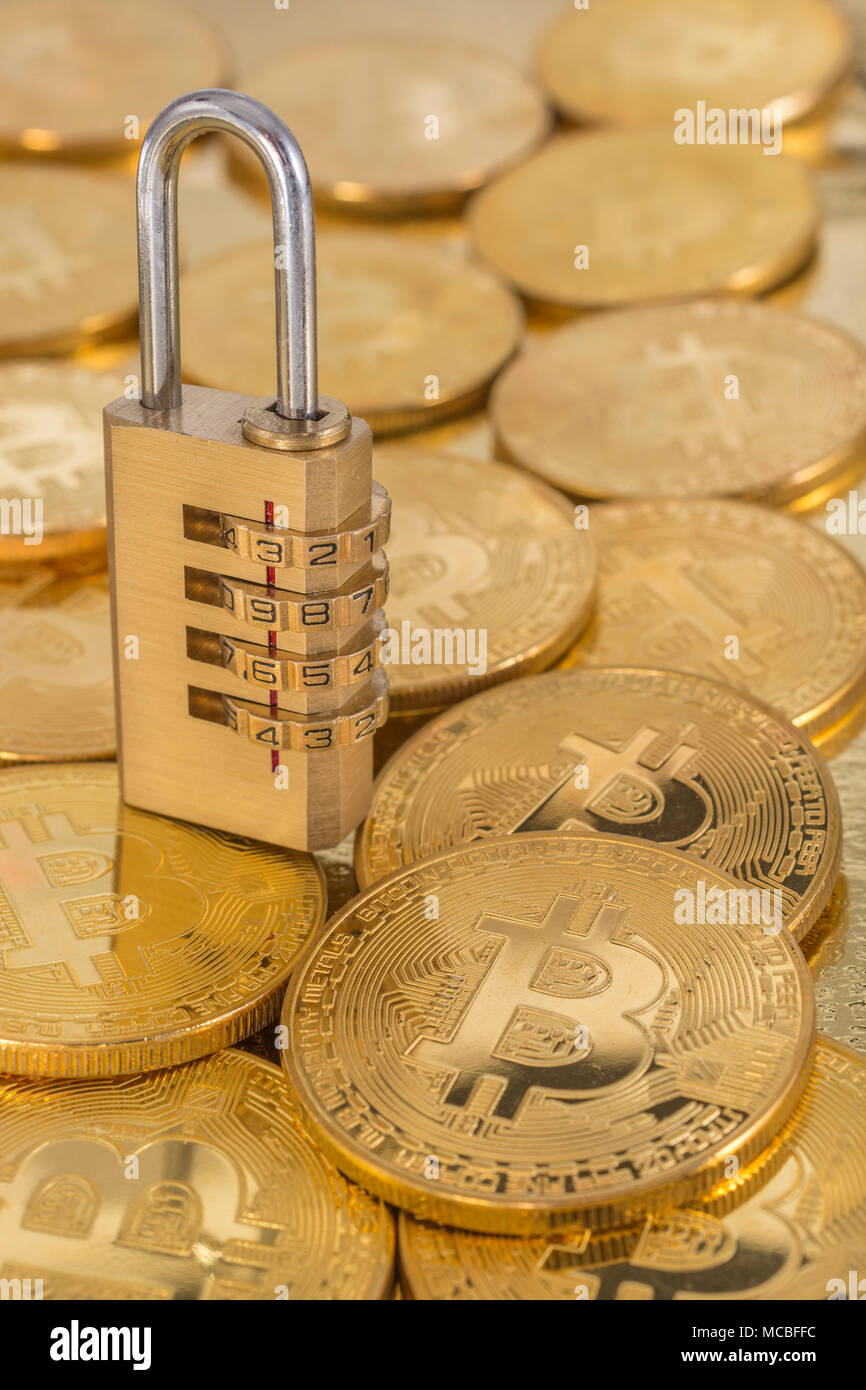 Macro-photo of small padlock with gold Bitcoins - as visual metaphor for Blochain / Bitcoin blockchain. China Blockchain conference metaphor. Stock Photo