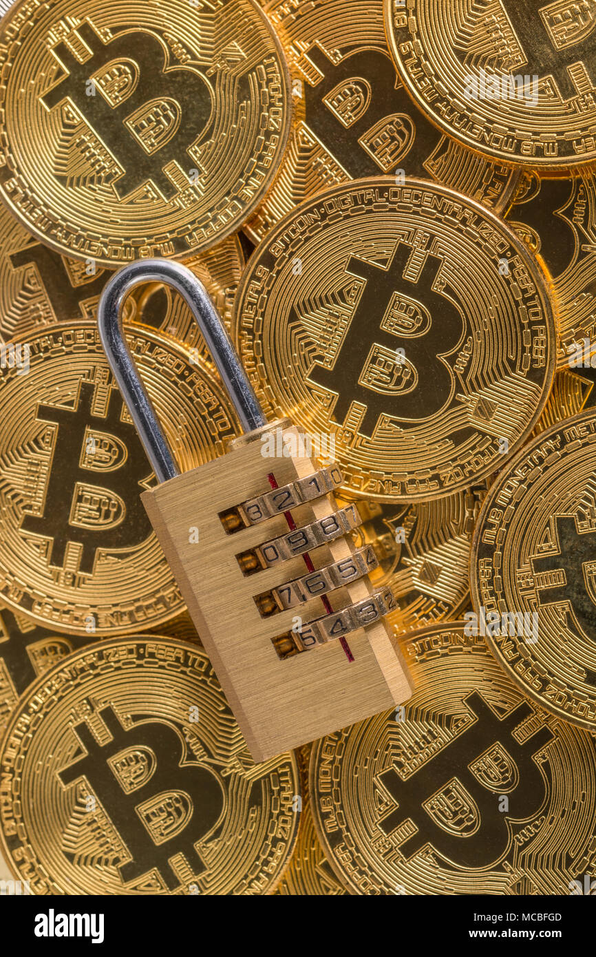 Macro-photo of small padlock with gold Bitcoins - as visual metaphor for Blochain / Bitcoin blockchain. Stock Photo