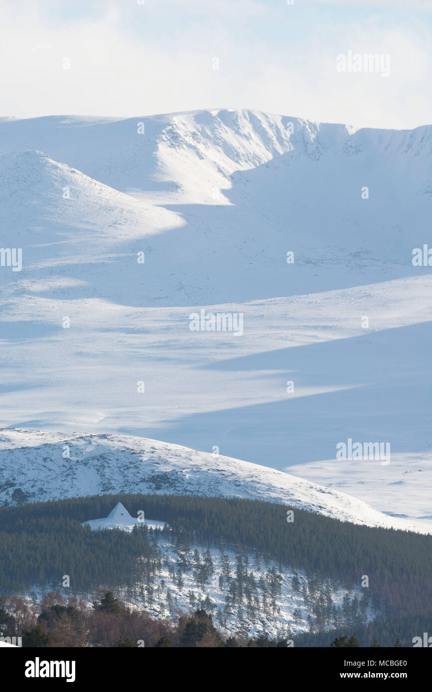 A Distant View of Prince Albert's Cairn, Standing on a Wooded Hillside on Balmoral Estate on Royal Deeside, with the slopes of Lochnagar as a Backdrop Stock Photo