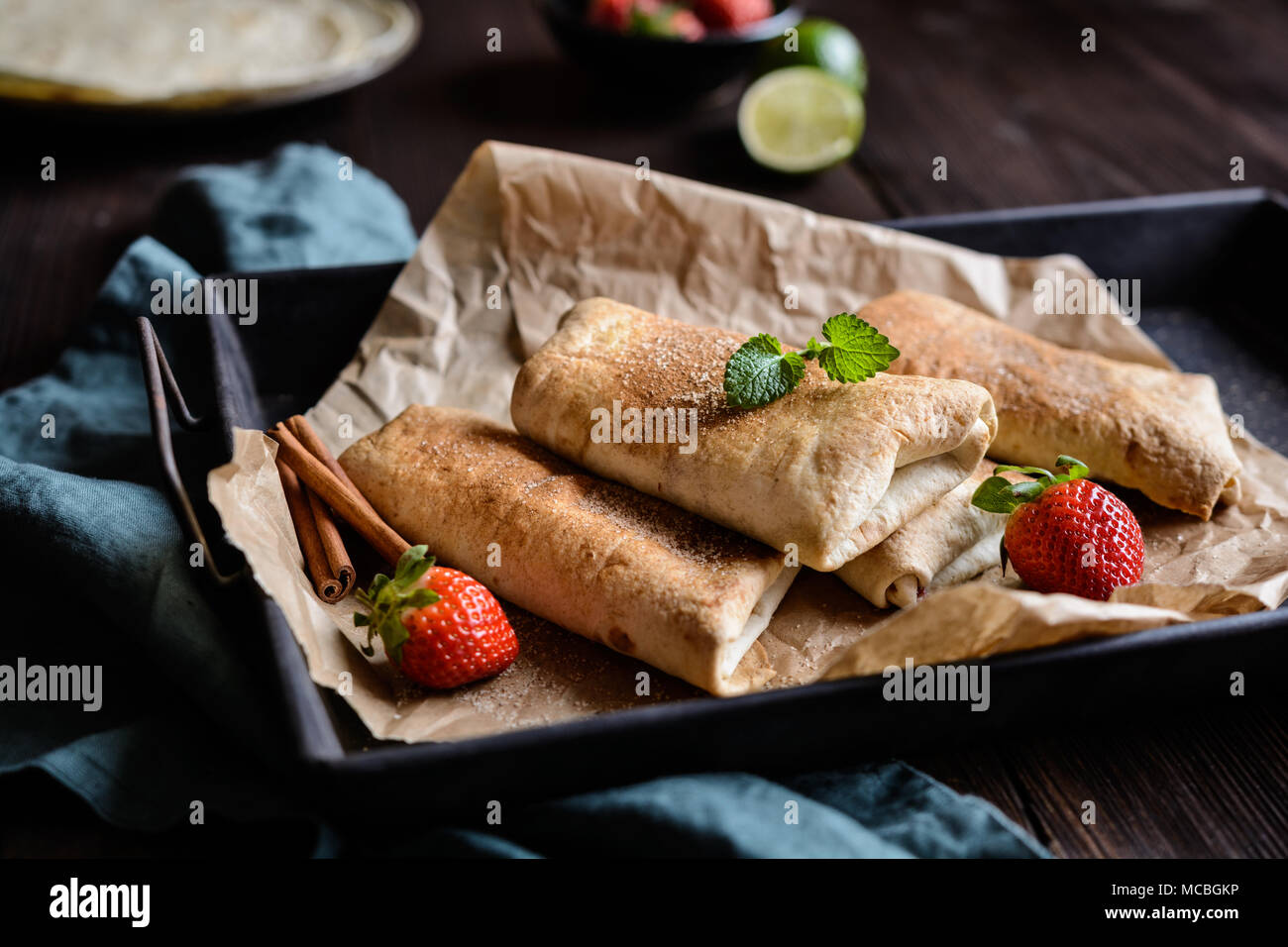Sweet baked Chimichangas with strawberry filling and cinnamon sugar icing Stock Photo