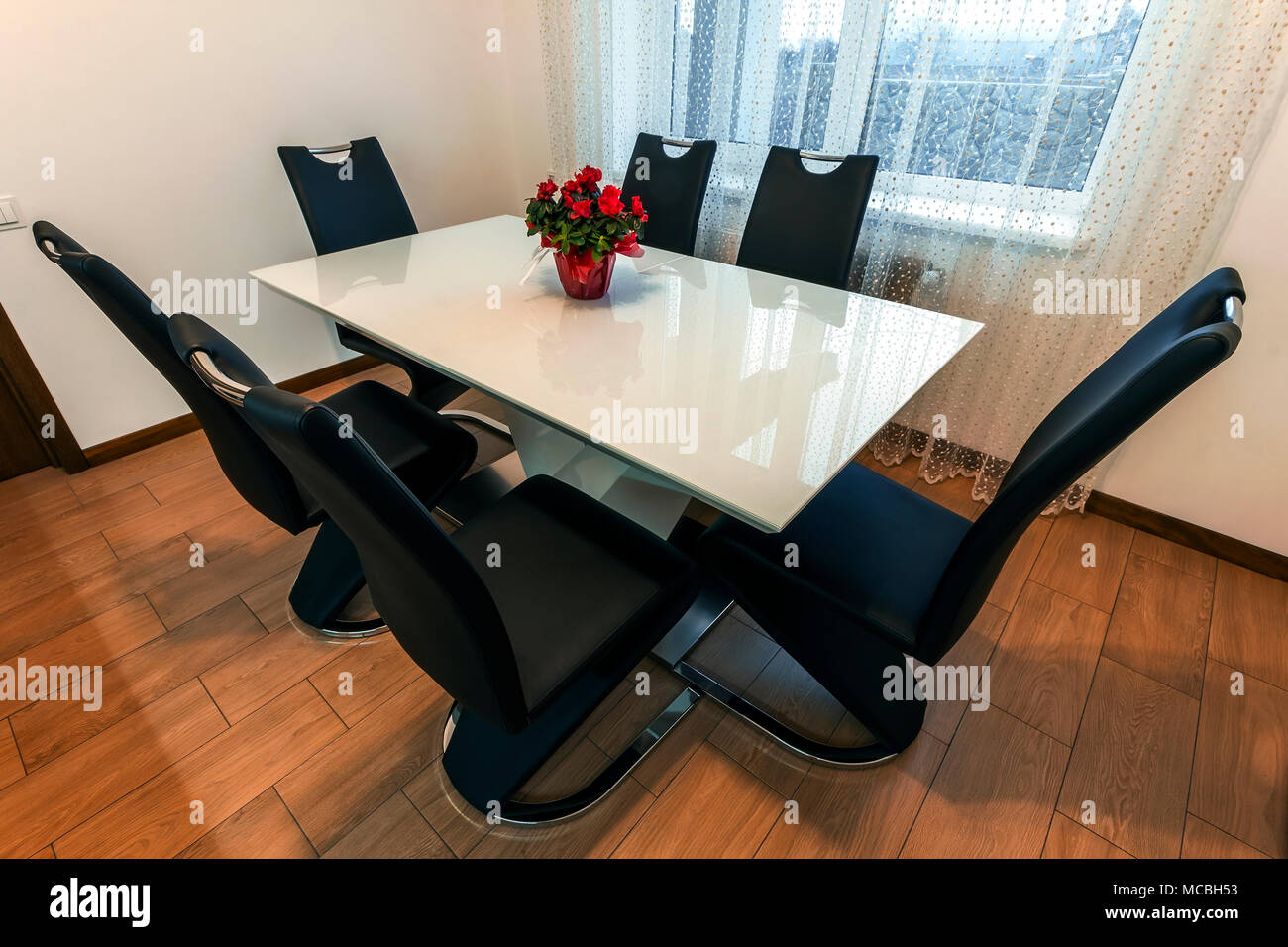 White wooden and glass round dining table with six chairs. Modern
