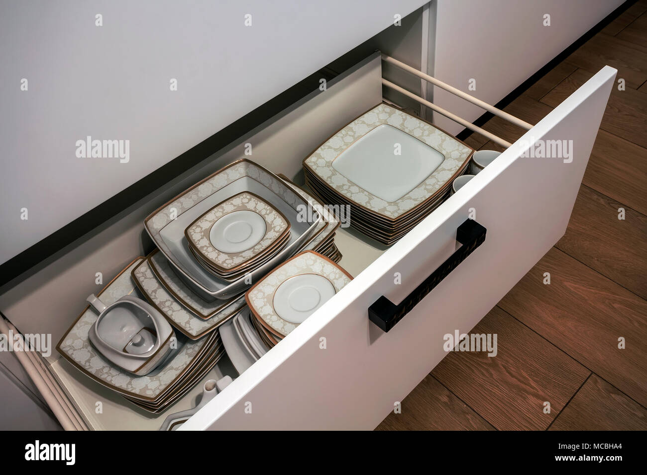 Open kitchen drawer with plates inside, a smart solution for kitchen
