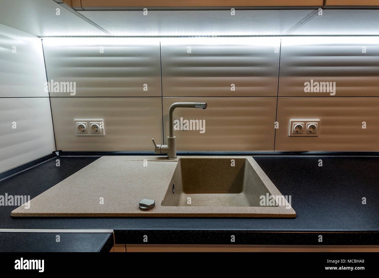 Granite sink and water faucet in new modern kitchen interior Stock