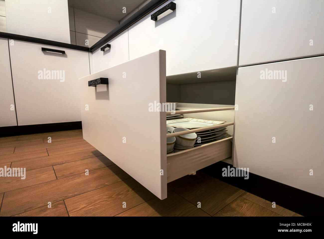 Open kitchen drawer with plates inside, a smart solution for kitchen
