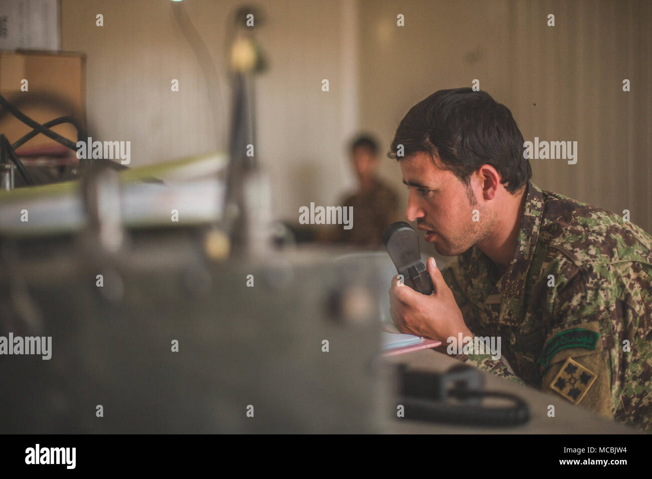 A soldier with 1st Brigade, Afghan National Army (ANA) 215th Corps speaks to friendly forces during Operation Maiwand 12 at Camp Shorserack, Afghanistan, March 10, 2018. Operation Maiwand 12 is an Afghan-led, Task Force Southwest-assisted operation with maneuver elements from the ANA 215th Corps, National Directorate of Security, and 505th Zone Afghan National Police forces to expand the security belt in Helmand Province. Stock Photo