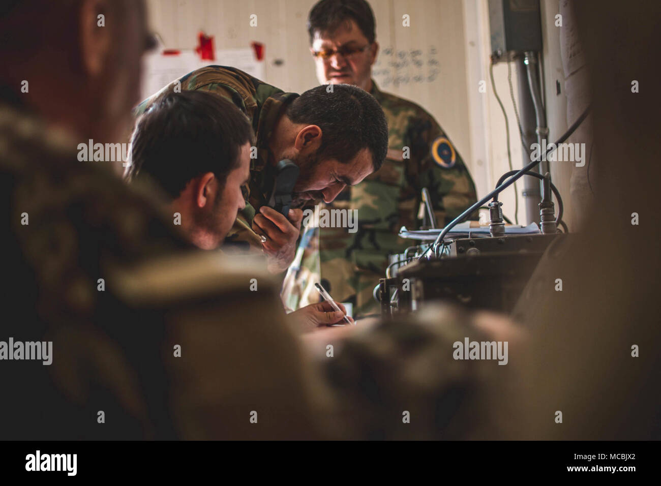 Soldiers with 1st Brigade, Afghan National Army (ANA) 215th Corps speak to friendly forces during Operation Maiwand 12 at Camp Shorserack, Afghanistan, March 12, 2018. Operation Maiwand 12 is an Afghan-led, TFSW-assisted, operation with maneuver elements from the ANA 215th Corps, National Directorate of Security, and 505th Zone Afghan National Police forces to expand the security belt in Helmand Province. Stock Photo