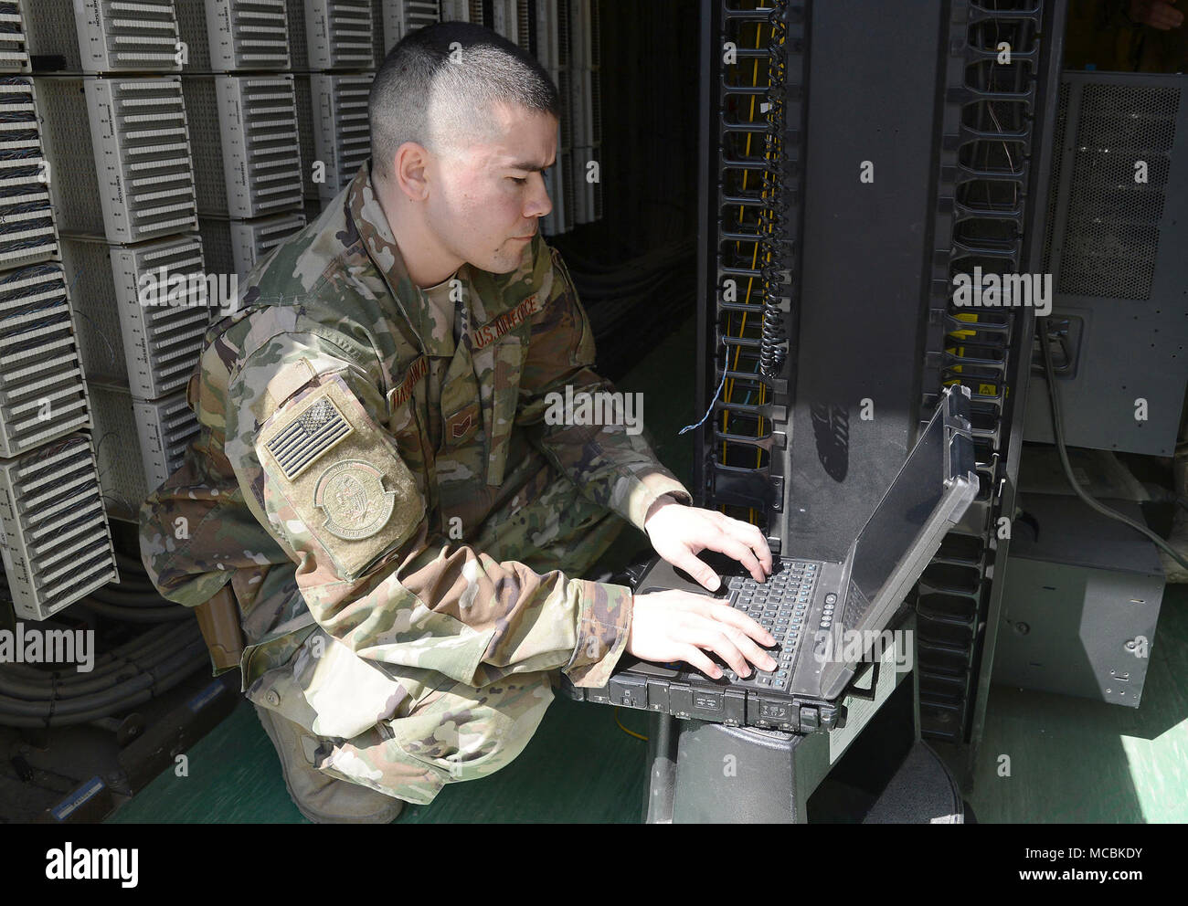 Staff Sgt. Brandon Hasegawa, 455th Expeditionary Communication Squadron cyber transport technician, activates a network port Mar. 22, 2018 at Bagram Airfield, Afghanistan. In addition to maintaining and managing the network, Hasegawa stays busy dealing with vulnerability issues, testing and troubleshooting network systems equipment as well as port activations. Stock Photo