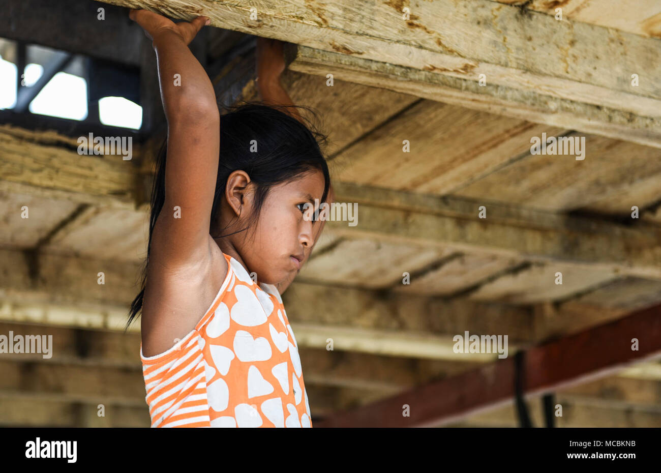 A child in the Cémaco Province, Panama, holds on to a raised floor March 28, 2018, during Exercise New Horizons 2018. Exercise New Horizons is a joint training exercise where all branches of the U.S. military conduct training in civil engineer, medical and support services while benefiting the local community. The exercise will assist children throughout the region by providing medical assistance and facilities such as schools, a youth community center and a women’s health ward. Stock Photo