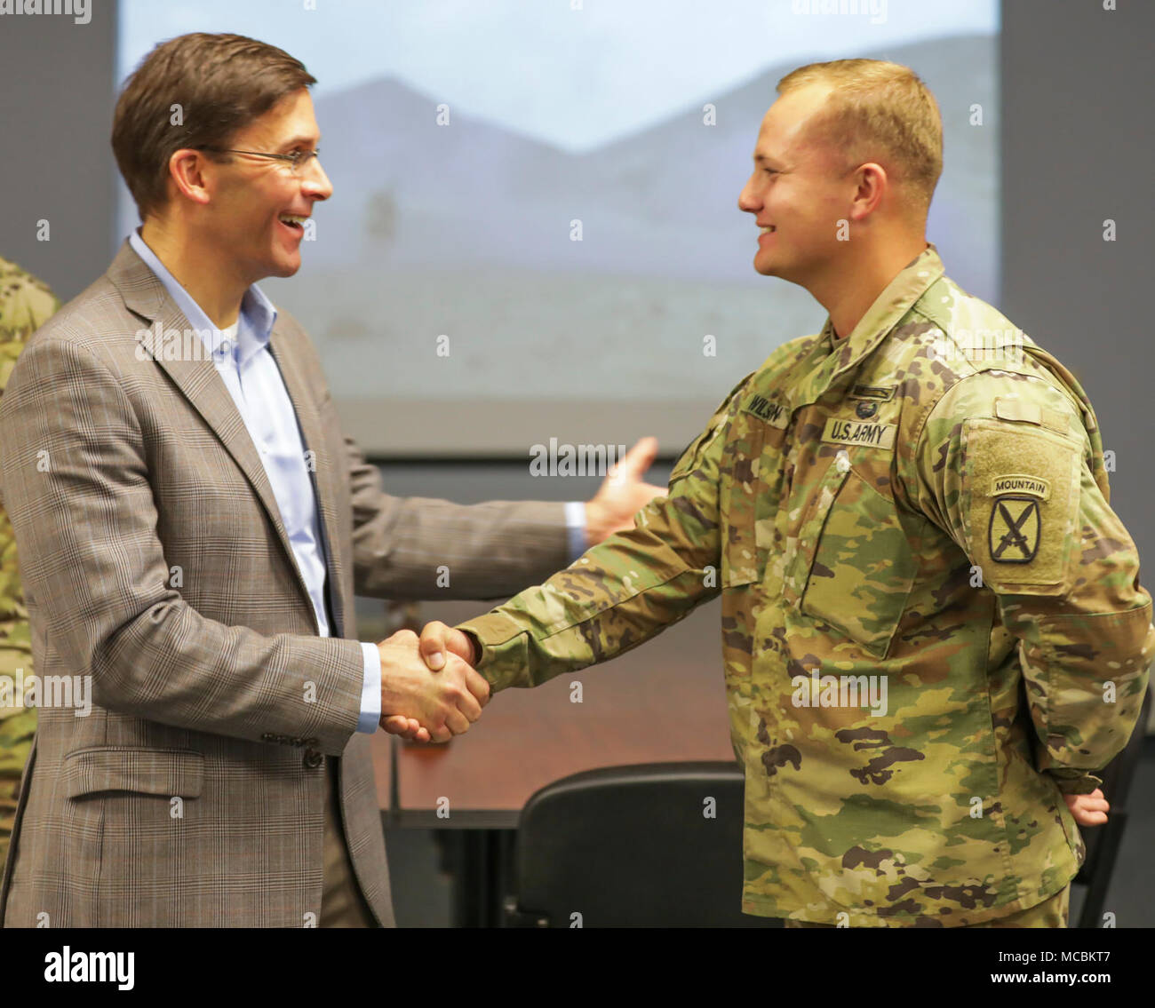 Secretary of the Army, Dr. Mark Esper (left) awards Spc. Holden Wilson, 1st Brigade Combat Team, 10th Mountain Division with a Challenge Coin for his achievements while deployed to Djibouti, Africa as part of the East Africa Response Force within the Regionally Aligned Forces Mission in support of Combined Joint Task Force-Horn of Africa. Wilson is a native of Pisgah, Alabama. Stock Photo