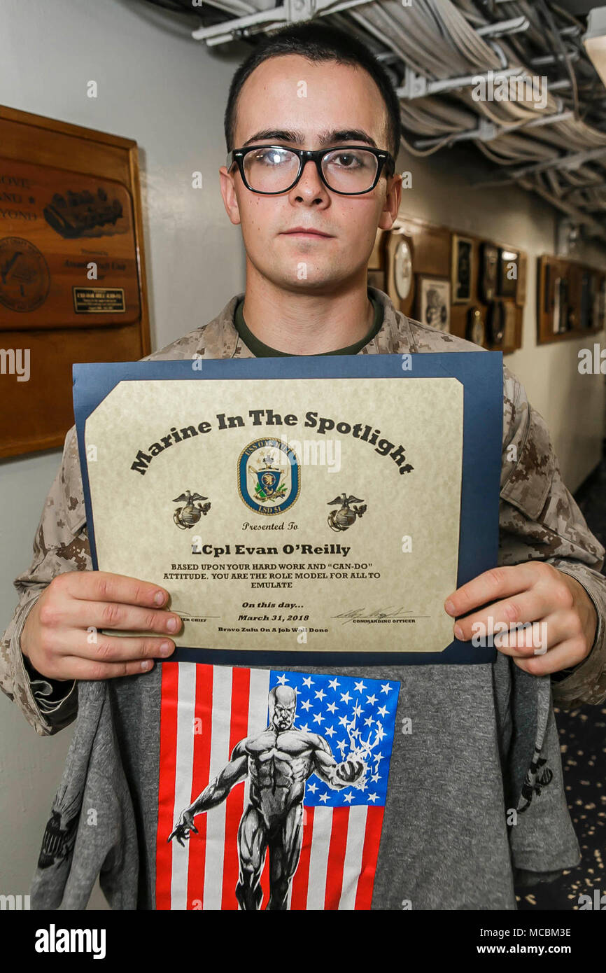 U.S. 5TH FLEET AREA OF OPERATIONS (March 31, 2018) Marine Corps Lance Cpl. Jonathon M. Conklin, 20, a native of Gardner, Massachusetts and team leader assigned to Fox Company, Battalion Landing Team, 2nd Battalion, 6th Marine Regiment, 26th Marine Expeditionary Unit, the Marine in the Spotlight award winner for the week, is presented with a certificate and shirt aboard the Harpers Ferry-class dock landing ship USS Oak Hill (LSD 51). The Oak Hill is deployed to the U.S. 5th Fleet area of operations in support of maritime security operations to reassure allies and partners and preserve the freed Stock Photo