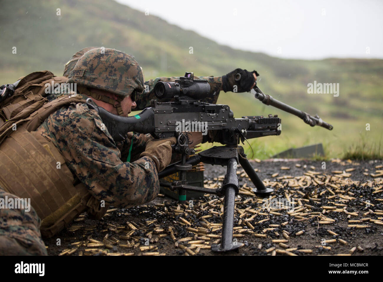 U.S. Marines with Bravo Company (Bravo Co.), 1st Battalion, 3rd Marine Regiment, fire a M240B machine gun during a squad supported exercise at the Kaneohe Bay Range Training Facility, Marine Corps Base Hawaii, Mar. 22, 2018. Bravo Co. utilized machine gun suppression and mortar fire on simulated enemy forces, while infantrymen assaulted forward towards them. This combined-forces exercise was the last day of the battalion’s training event, Exercise Bougainville One, an annual training exercise that strengthens pre-deployment readiness. Stock Photo