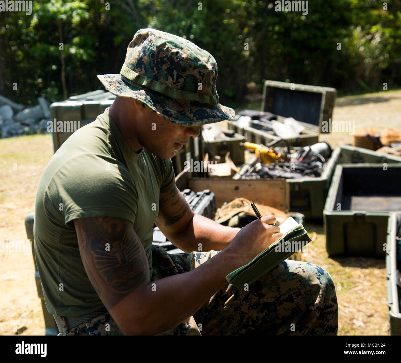 Lance Cpl. Desean White, a combat engineer with 2nd Platoon, A Co., 9th Engineer Support Battalion, 3rd Marine Logistics Group inventories tools during vertical construction training March 26, 2018, Camp Hansen, Okinawa, Japan. Vertical construction training prepares Marines for similar projects they will be entrusted with during humanitarian assistance operations. The engineers use a number of different tools and must check each one out with White due to the importance of gear accountability. White is a native of Bronx, New York. Stock Photo