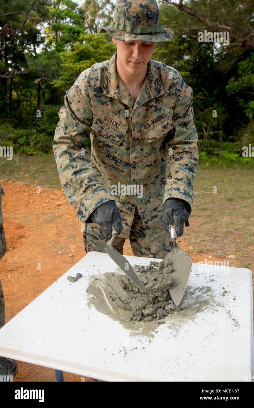 Lance Cpl. Tristan Steckl with 2nd Platoon, A Co., 9th Engineer Support Battalion, 3rd Marine Logistics Group, mixes mortar to hold concrete blocks together during vertical construction training March 26, 2018, Camp Hansen, Okinawa, Japan. Mortar is a mixture of concrete, water and sand and must be mixed properly in order for the concrete blocks to stick together and be even. Vertical construction training prepares Marines for similar projects they will be entrusted with during humanitarian assistance operations. Steckl is a native of Waukesha, Wisconsin. Stock Photo
