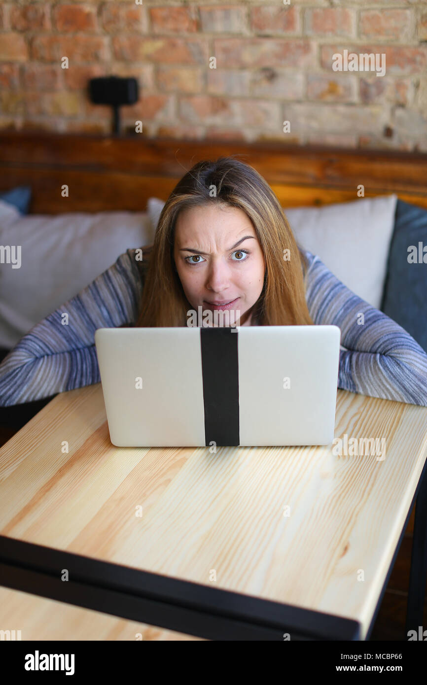 Female sitting on wooden chair near table and posing for photo Stock