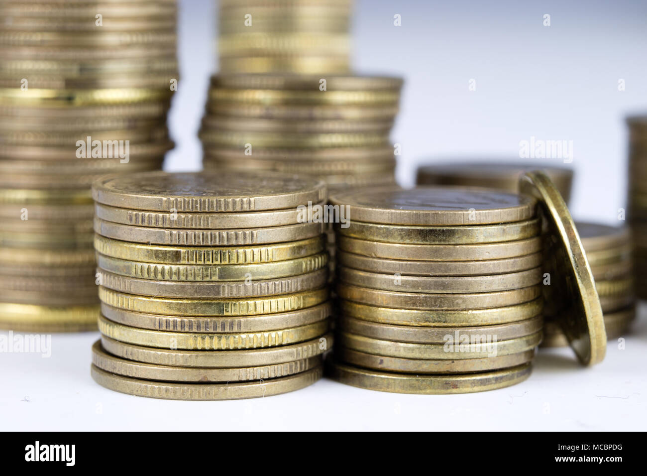 Coins stacked. Money lying on the table. White background. Stock Photo