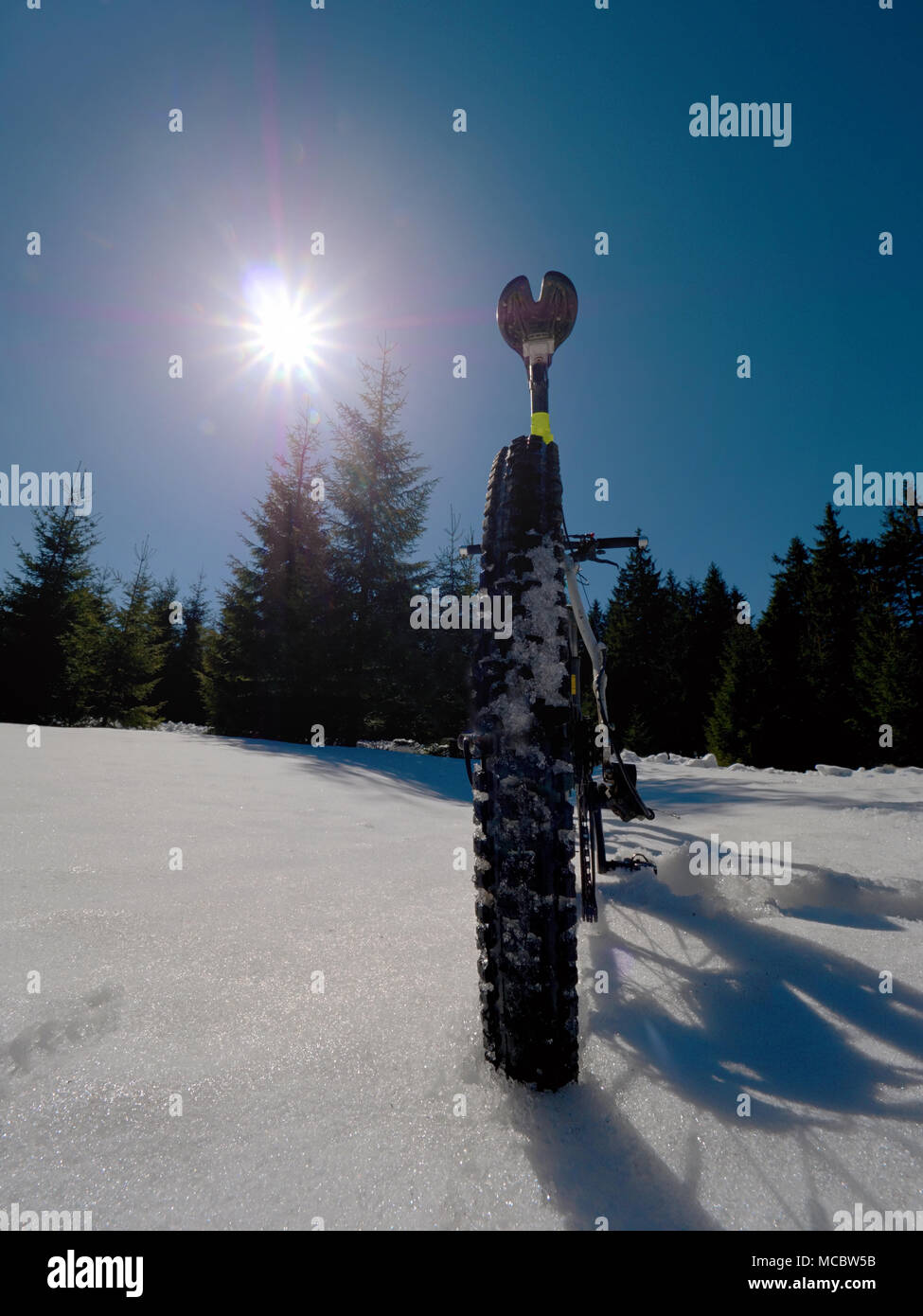 Mountain bike in snow. Cycling on large tire wheels in fresh snow. Cyclist goes on bike on the