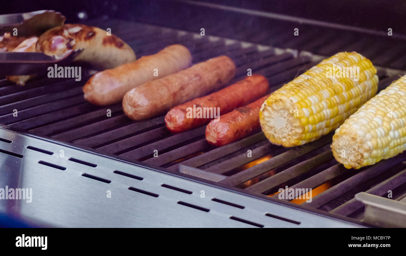 Cooking hot dogs and bratwurst on outdoor gas grill in the Summer Stock Photo Alamy