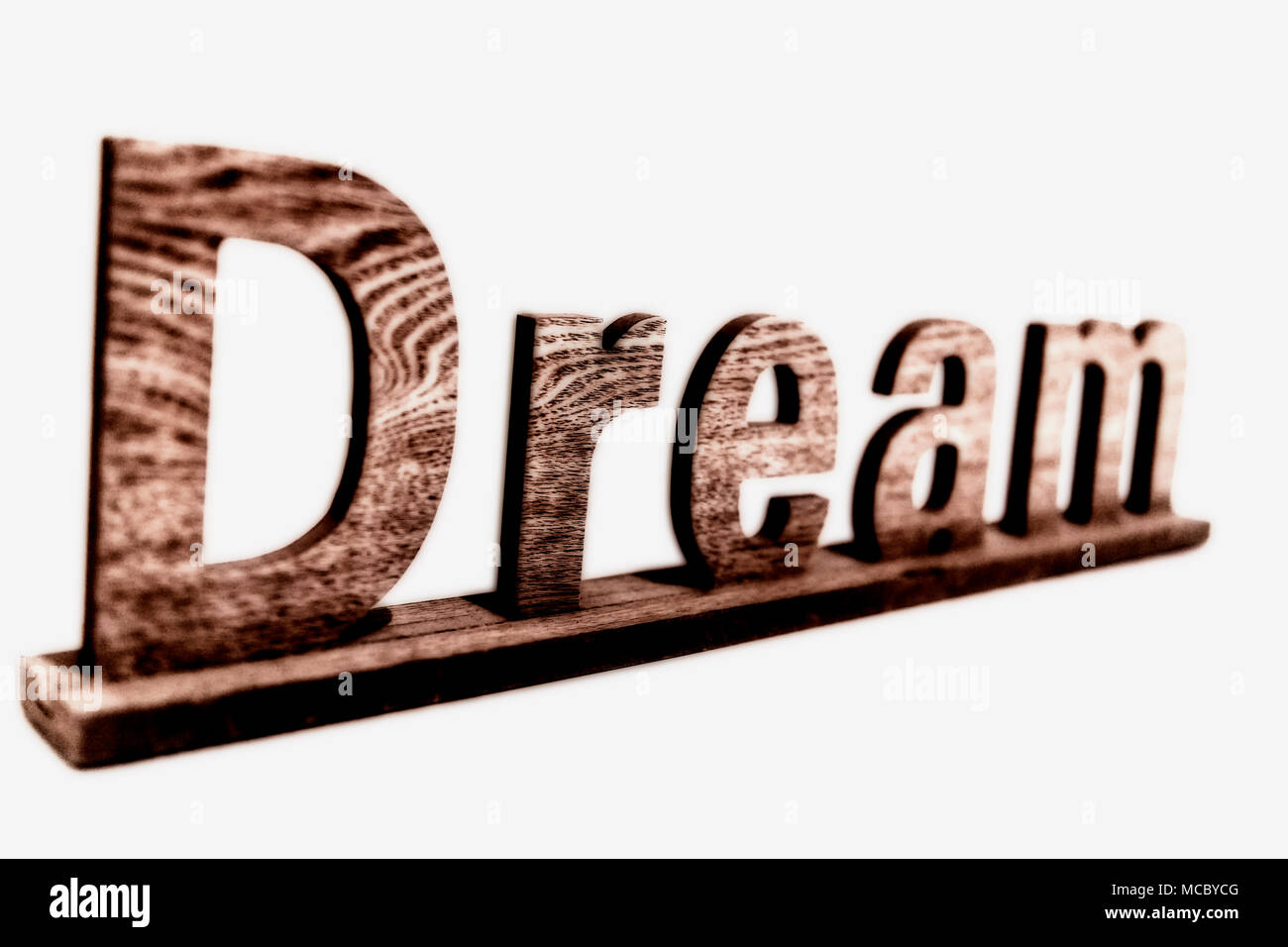 The word „dream“ in wooden letters - isolated in front of a white wall; das Wort “dream” in Holzbuchstaben vor einer weißen Wand Stock Photo