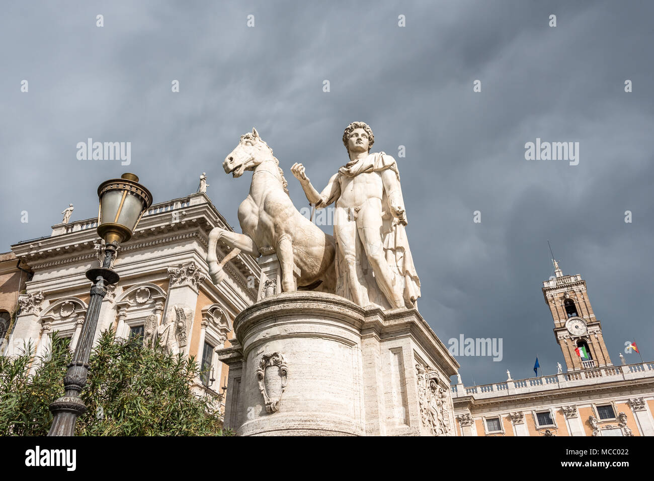 White marble sculpture of Castor and horse against cloudy sky at entrance to Piazza del Campidoglio, looking up from Cordonata stairs, Capitoline Hill Stock Photo