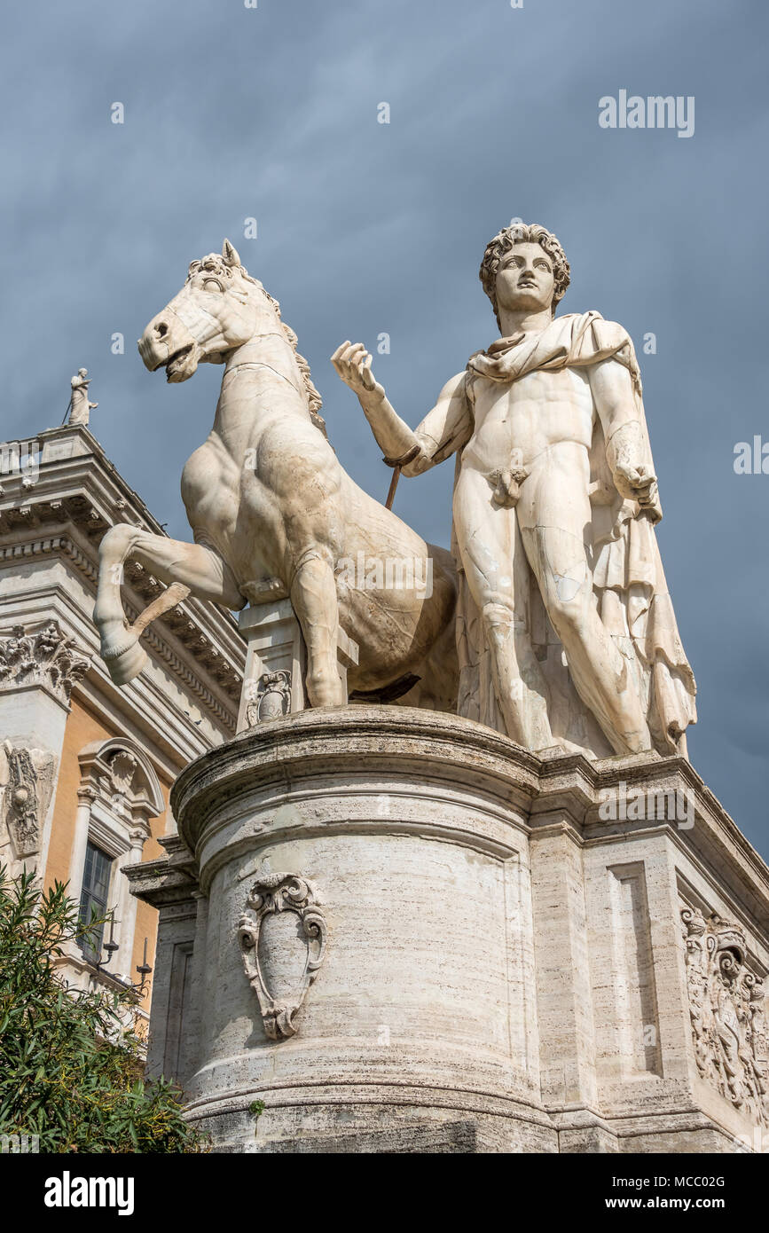 White marble sculpture of Castor and horse against cloudy sky at entrance to Piazza del Campidoglio, looking up from Cordonata stairs, Capitoline Hill Stock Photo