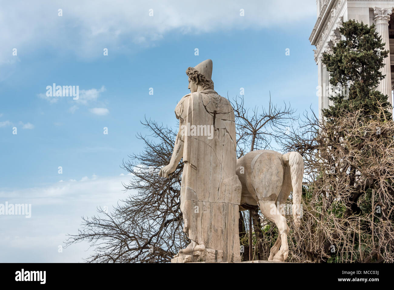 Marble statue of man in traditional pileus hat w/ horse at top of Capitoline Hill Cordonata steps near Vittorio Emanuele II, blue sky, white clouds Stock Photo