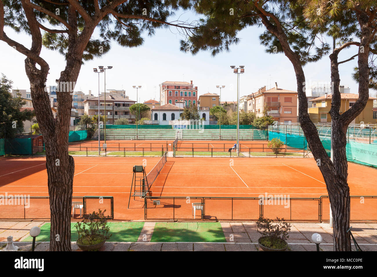 Deserted courts of the Lido Tennis Club, Lido di Venezia (Venice Lido),  Venice, Veneto, Italy with a lone member relaxing in a chair enjoying the  spri Stock Photo - Alamy