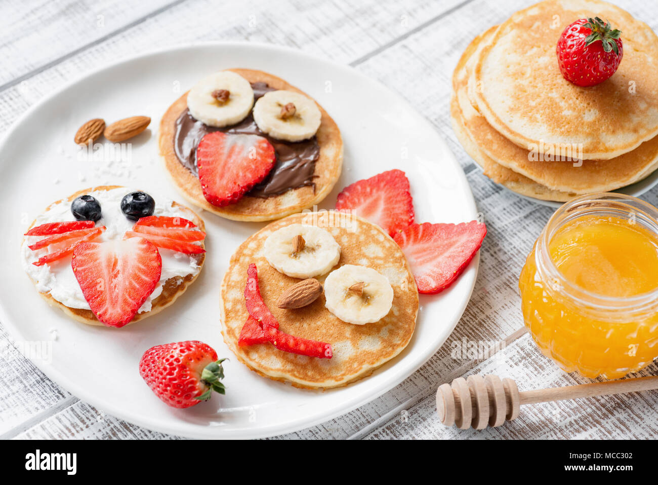Pancake food art for kids. Funny animal face pancakes on white plate. Kids meal Stock Photo