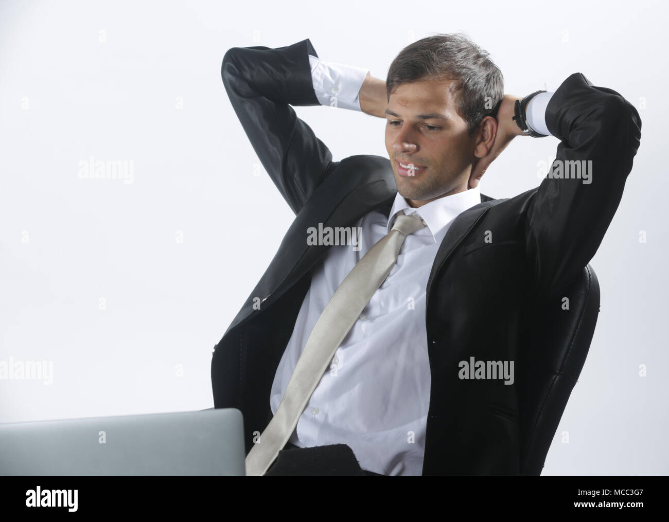 Man in shirt using laptop and thinking in his office Stock Photo