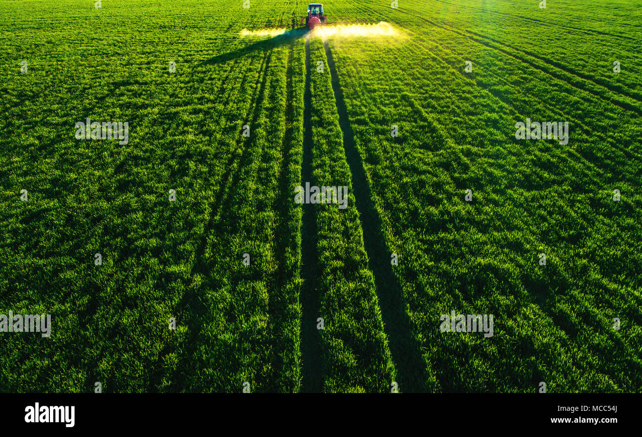 Aerial view of farming tractor plowing and spraying on field Stock ...