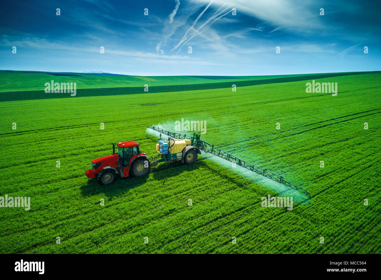 Aerial view of farming tractor plowing and spraying on field Stock ...
