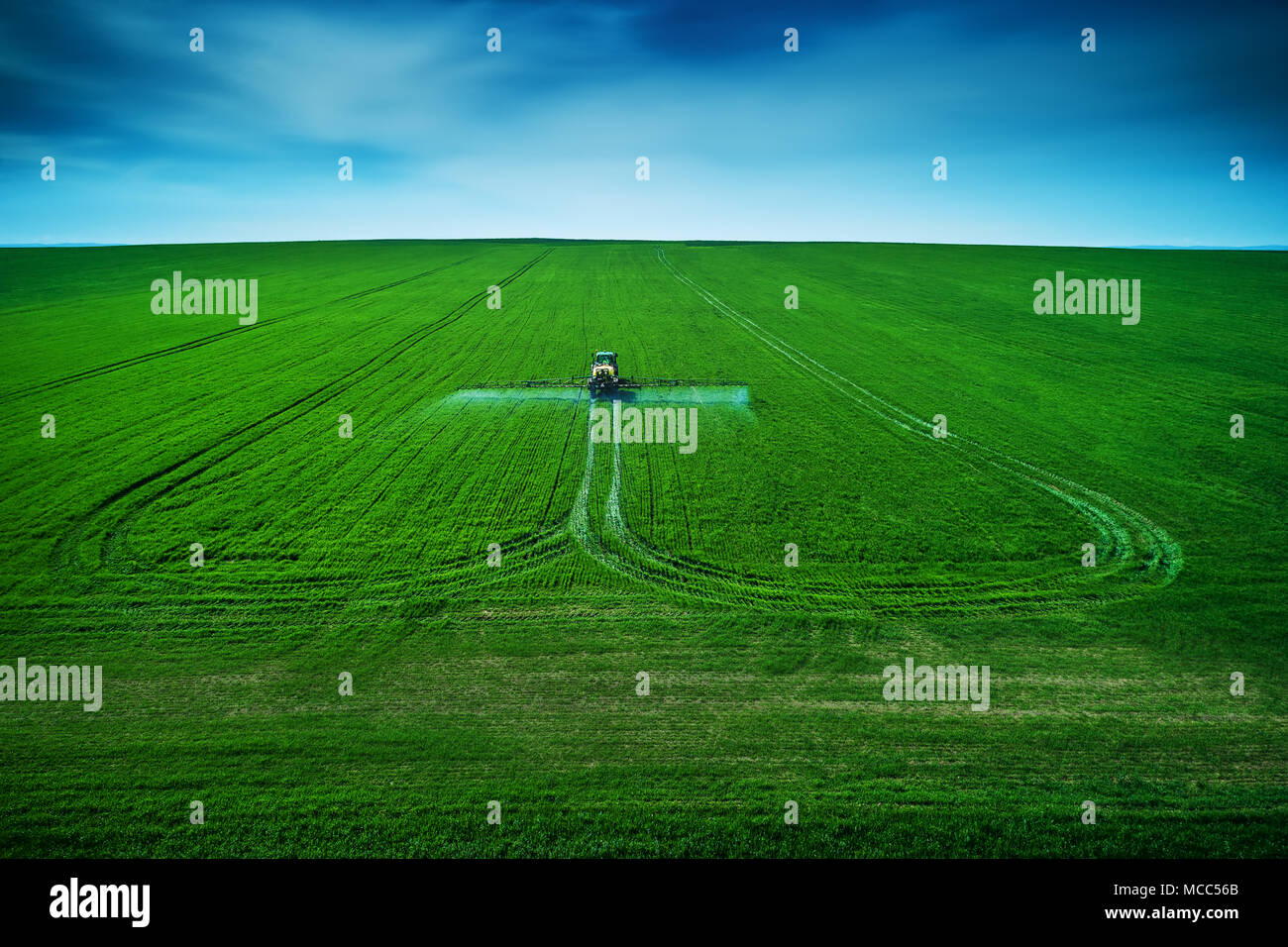 Aerial view of farming tractor plowing and spraying on field Stock ...