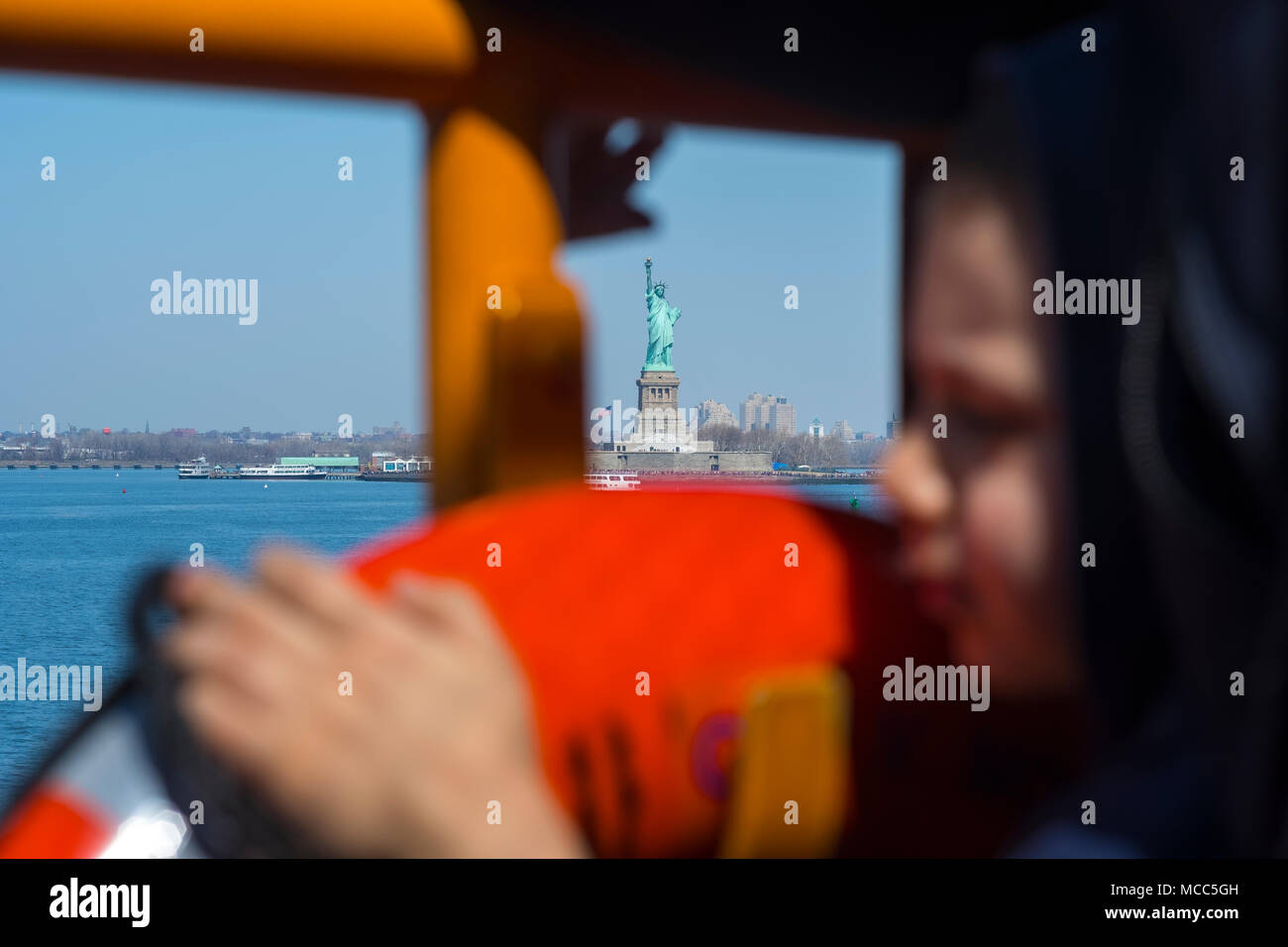 Young New Yorker on Staten Island Ferry passing Lady Liberty, April 2018 Stock Photo