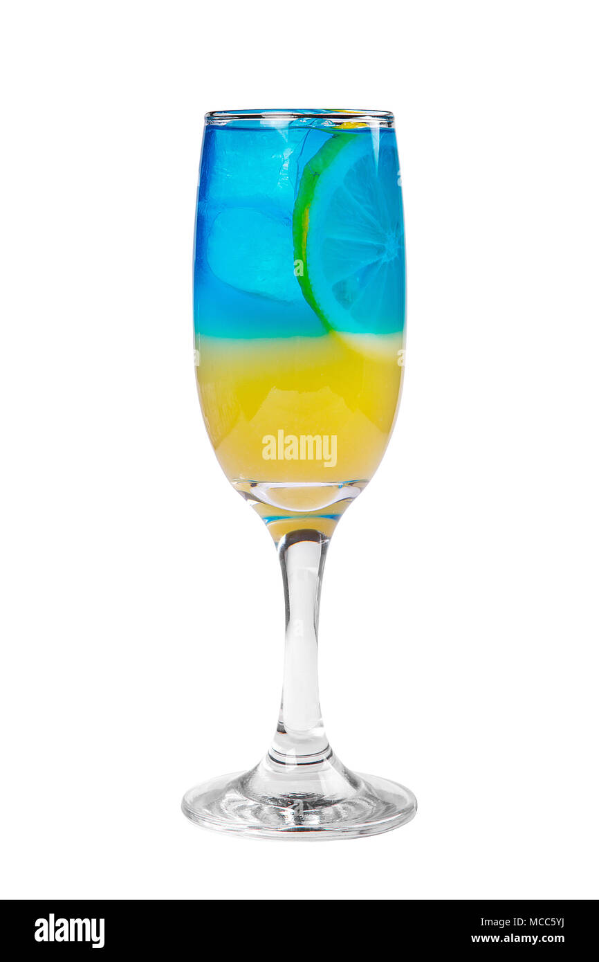 A multi-colored, two-layered yellow and blue cocktail in a high glass with ice cubes with the taste of pineapple, orange and a slice of lemon. Side vi Stock Photo