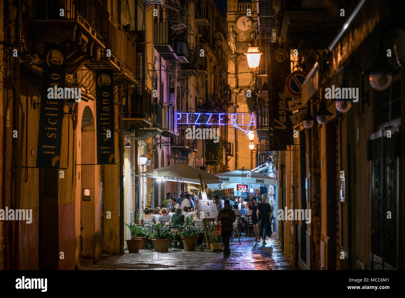 People sat outside eating at a Pizzeria in Palermo, Sicily, Italy, at night in summer. Stock Photo