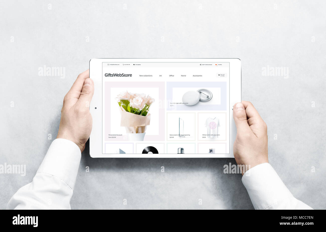 Hands holding tablet with gifts webstore mock up on screen, isolated. Clothing web page interface mockup. Internet website online template on the devi Stock Photo